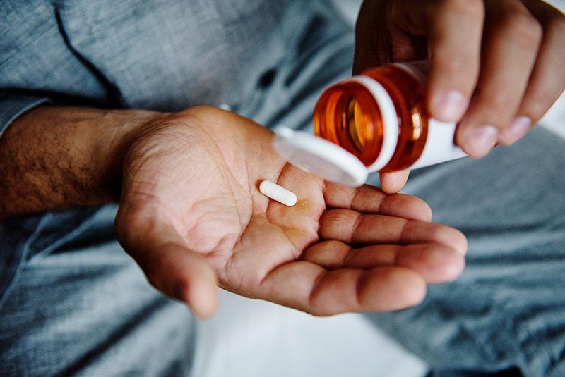 man taking medication after surgery